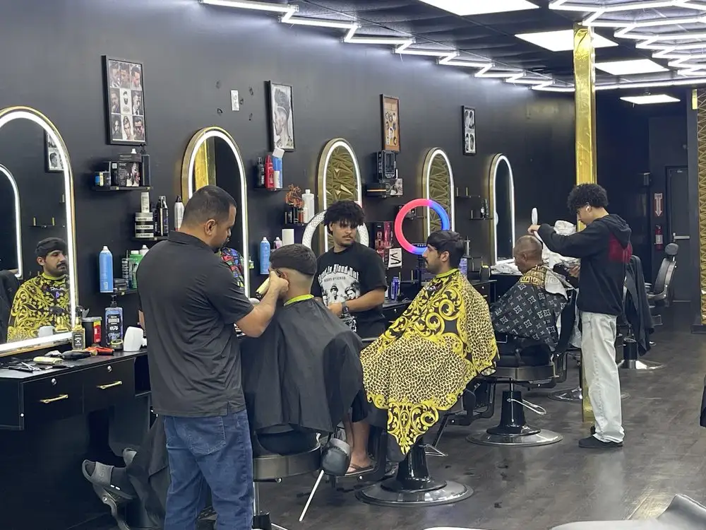 Barbers cutting hair at a row of arched mirrors