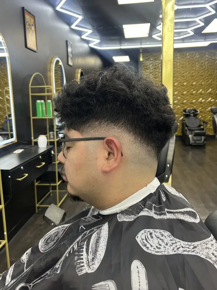 A curly top with a taper fade, side view