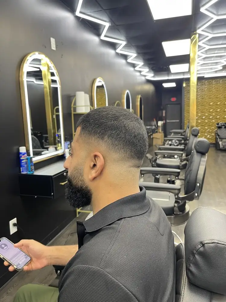 A client with a fade and beard in the chair