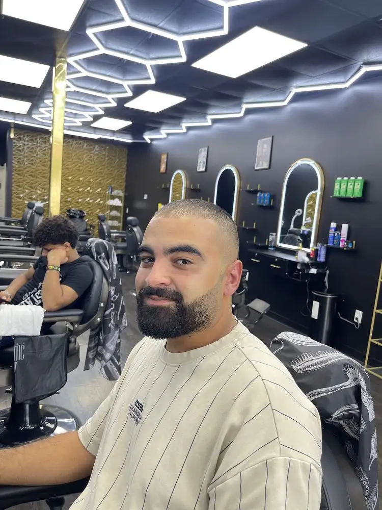A client with a buzz cut and full beard in the chair